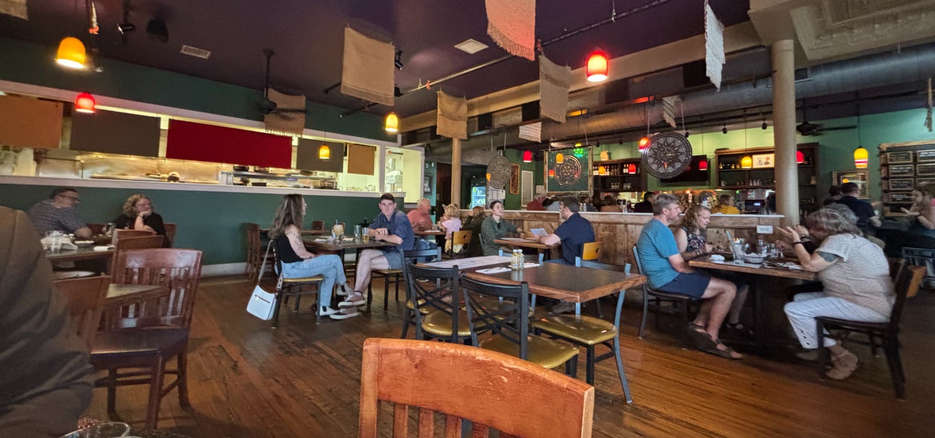 Interior of a restaurant with eclectic decor and people sitting at tables Interior of a restaurant with eclectic decor and people sitting at tables