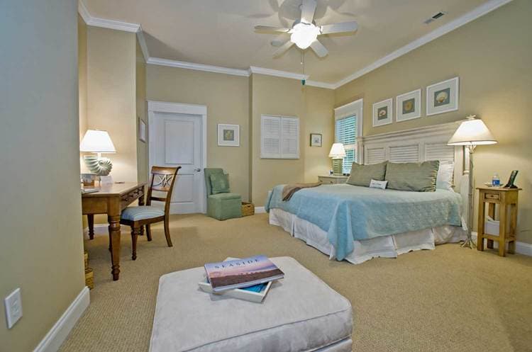 bed with aqua colored bedding and a seating area across from it