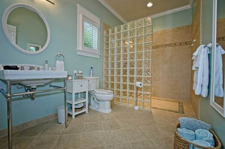 bathroom with aqua walls and white furnishings featuring ADA accessible 6-foot walk-in shower