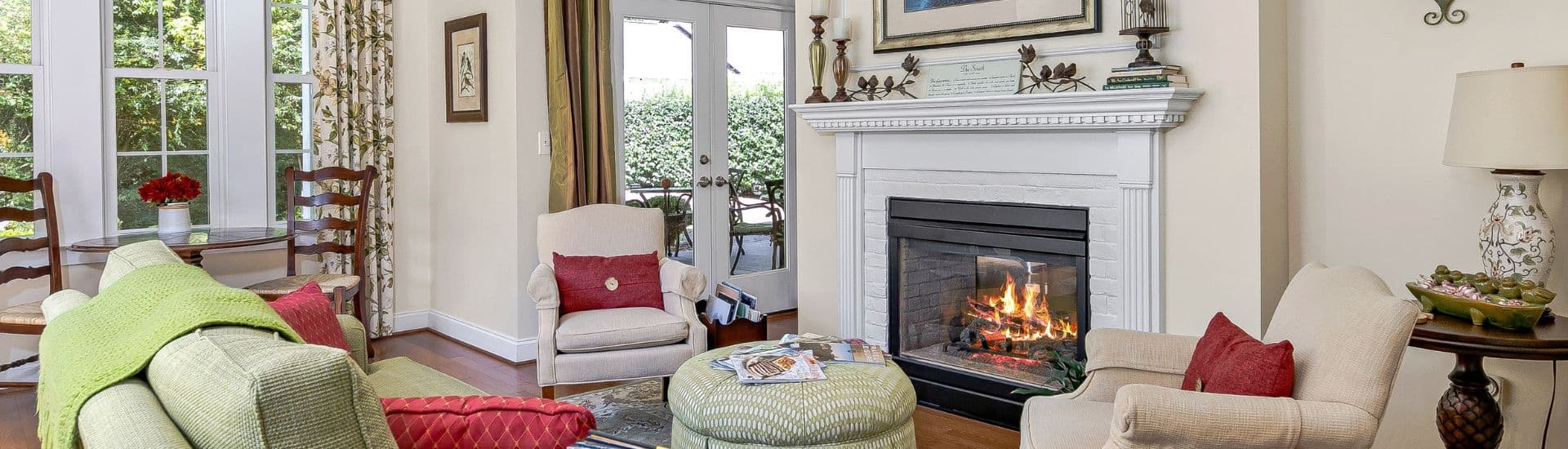 Cozy living room with a fireplace, comfortable seating, and large windows.