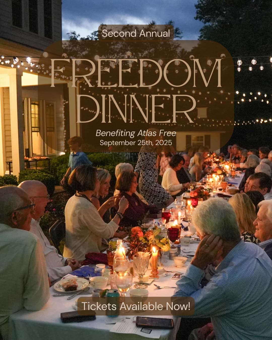 A warmly lit outdoor dinner event with guests gathered around a long table, promoting the Second Annual Freedom Dinner benefiting Atlas Free.