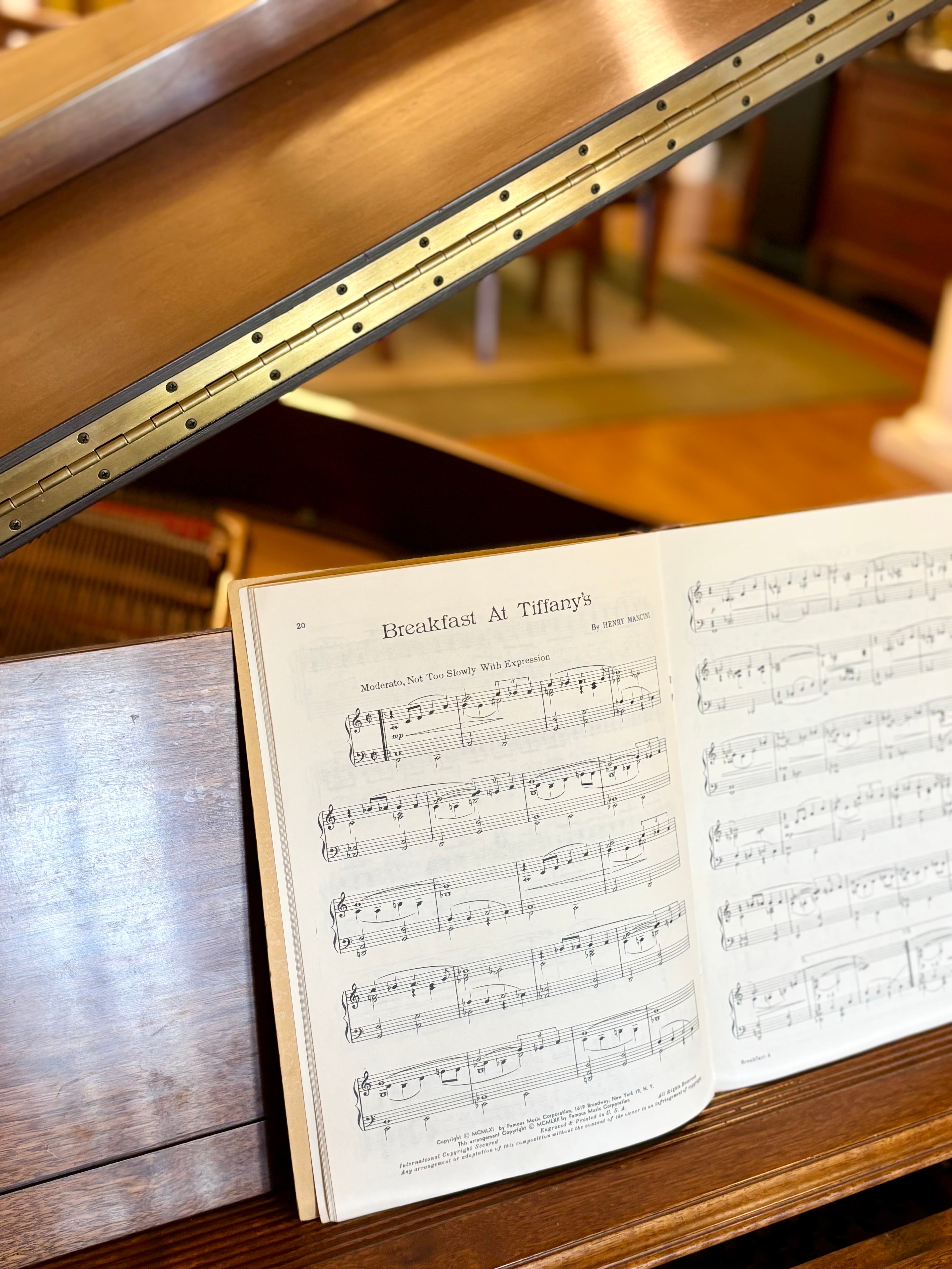 A close-up of an open sheet music book featuring "Breakfast at Tiffany's."